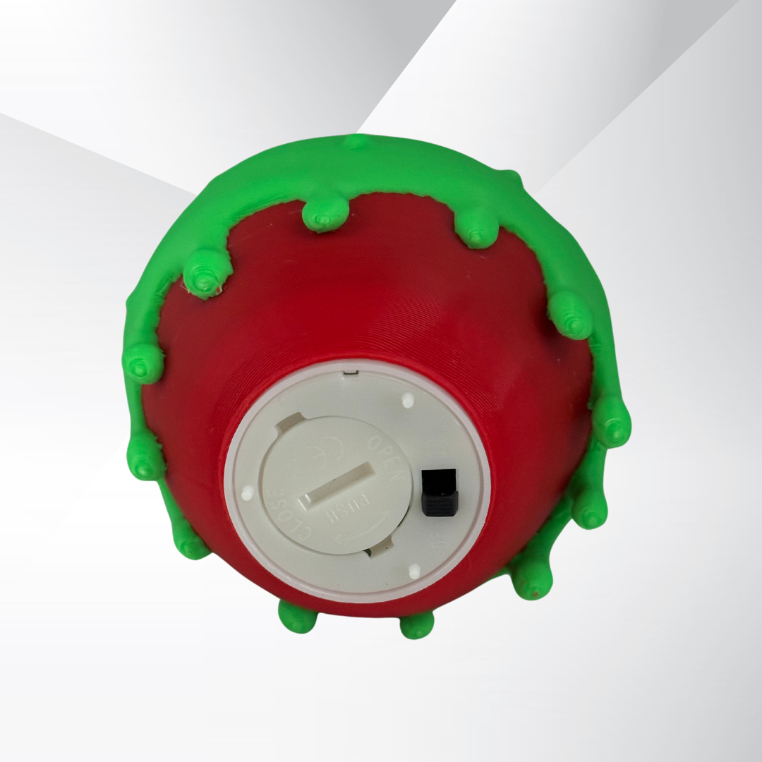 The bottom view of a poison candy apple light with the light turned off on a white background displaying the on and off switch for the batter powered light.