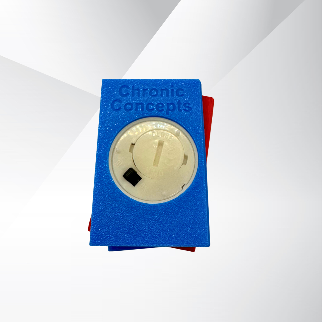 The bottom view of the vibrant red and blue light up stack of books, showing the on and off switch and where the batteries can be replaced on a white and silver background.