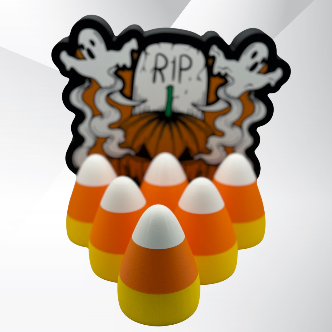 Multiple candy corn lights arranged in a pyramid in front of a Halloween sign.