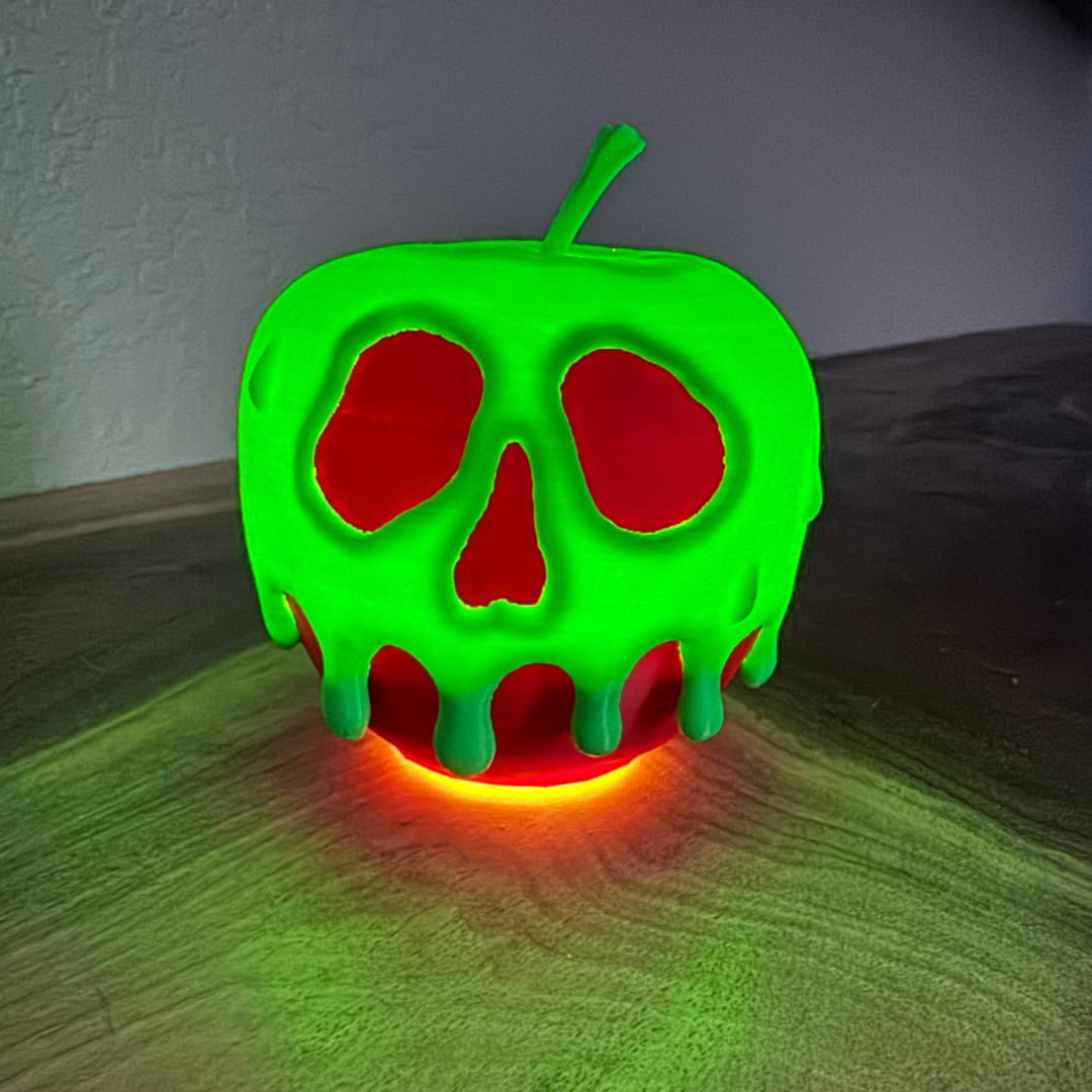 A poison candy apple Halloween decoration sitting on top of a wooden bookshelf.