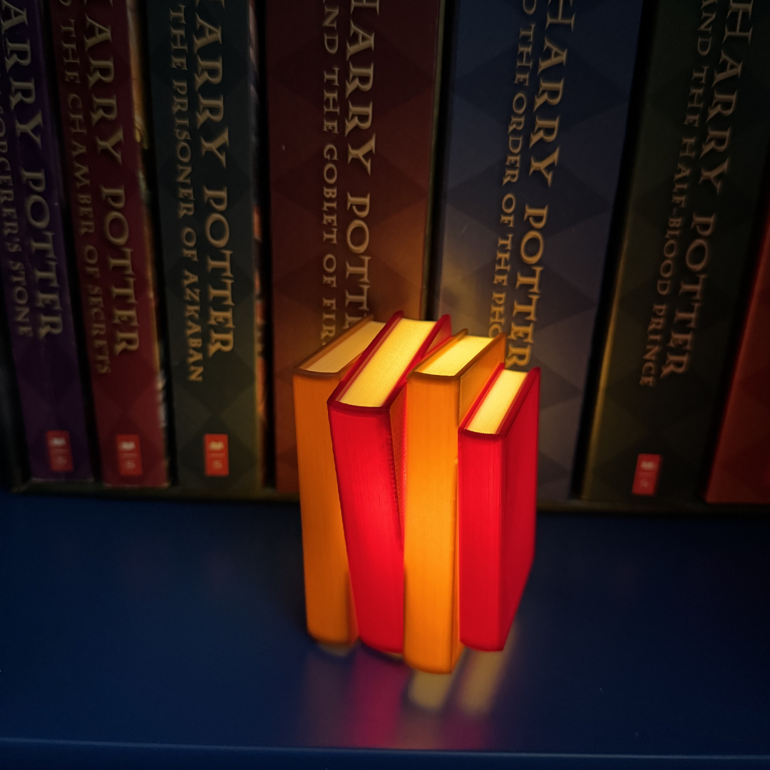 Maroon and brown book light standing up next to Harry Potter books.