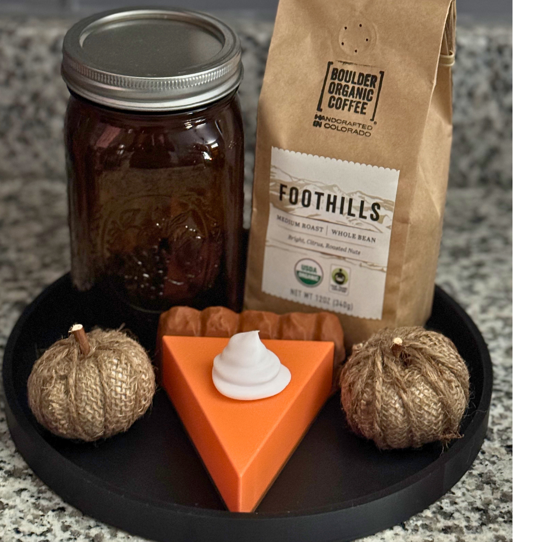 Pumpkin pie light on a fall display. Pumpkin pie light is sitting on a black tray with pumpkins, a mason jar, and coffee.