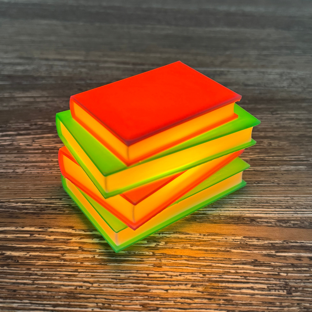 Neon pink and green light up stack of books lit up sitting on a wooden bookshelf.