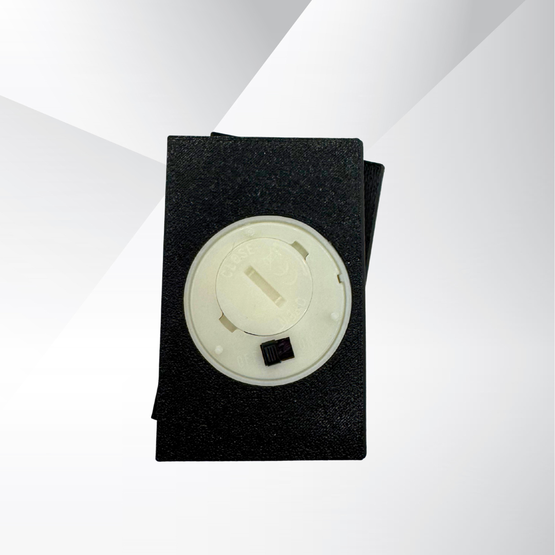 The bottom view of a True Crime Book Light with the light turned off on a white and silver background displaying the on and off switch for the battery powered light.