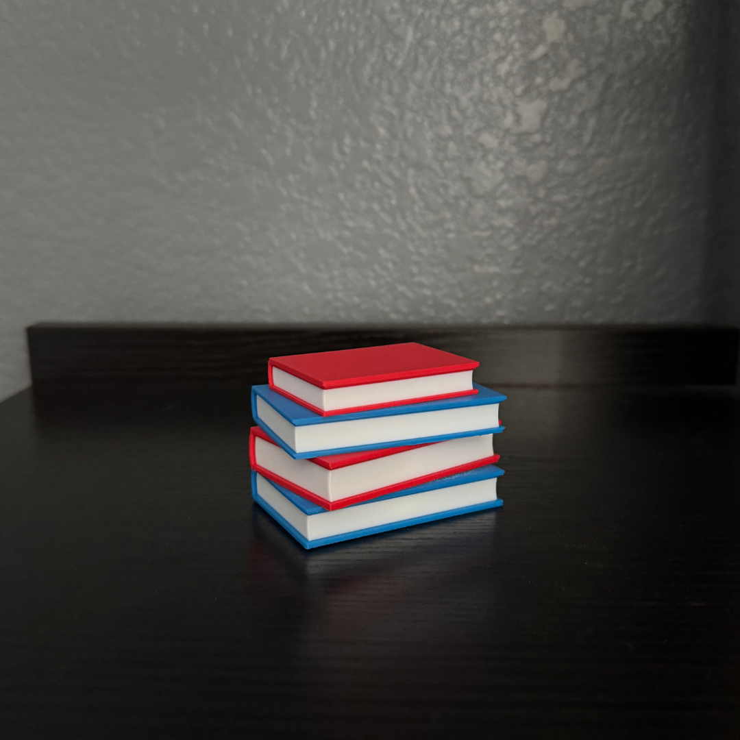 Vibrant red and blue light up stack of books with the light turned off sitting on a bookshelf.