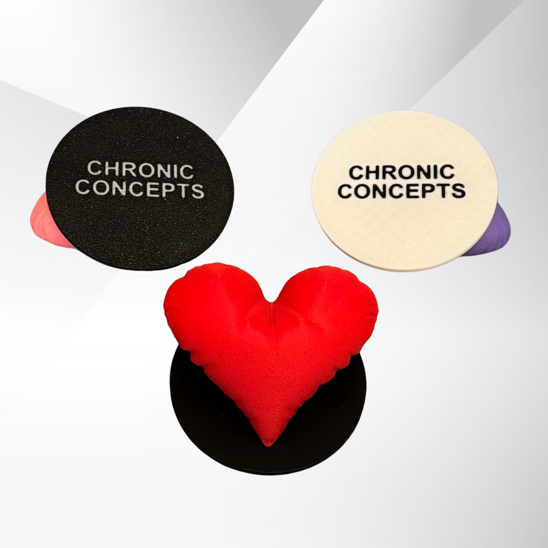 A red 3D printed heart sculpture with a black base and the bottoms of two other heart sculptures showing Chronic Concepts printed on the white base and black base.