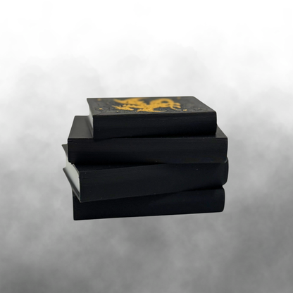 The binding view of a fantasy dragon light up stack of books with the light turned off on a smokey grey background.