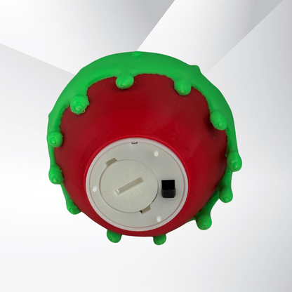 The bottom view of a poison candy apple light with the light turned off on a white background displaying the on and off switch for the batter powered light.