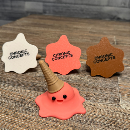 Bottom of three 3d printed melting ice cream cones made by Chronic Concepts sitting on a wooden table. Chocolate, Strawberry, and Vanilla flavored.