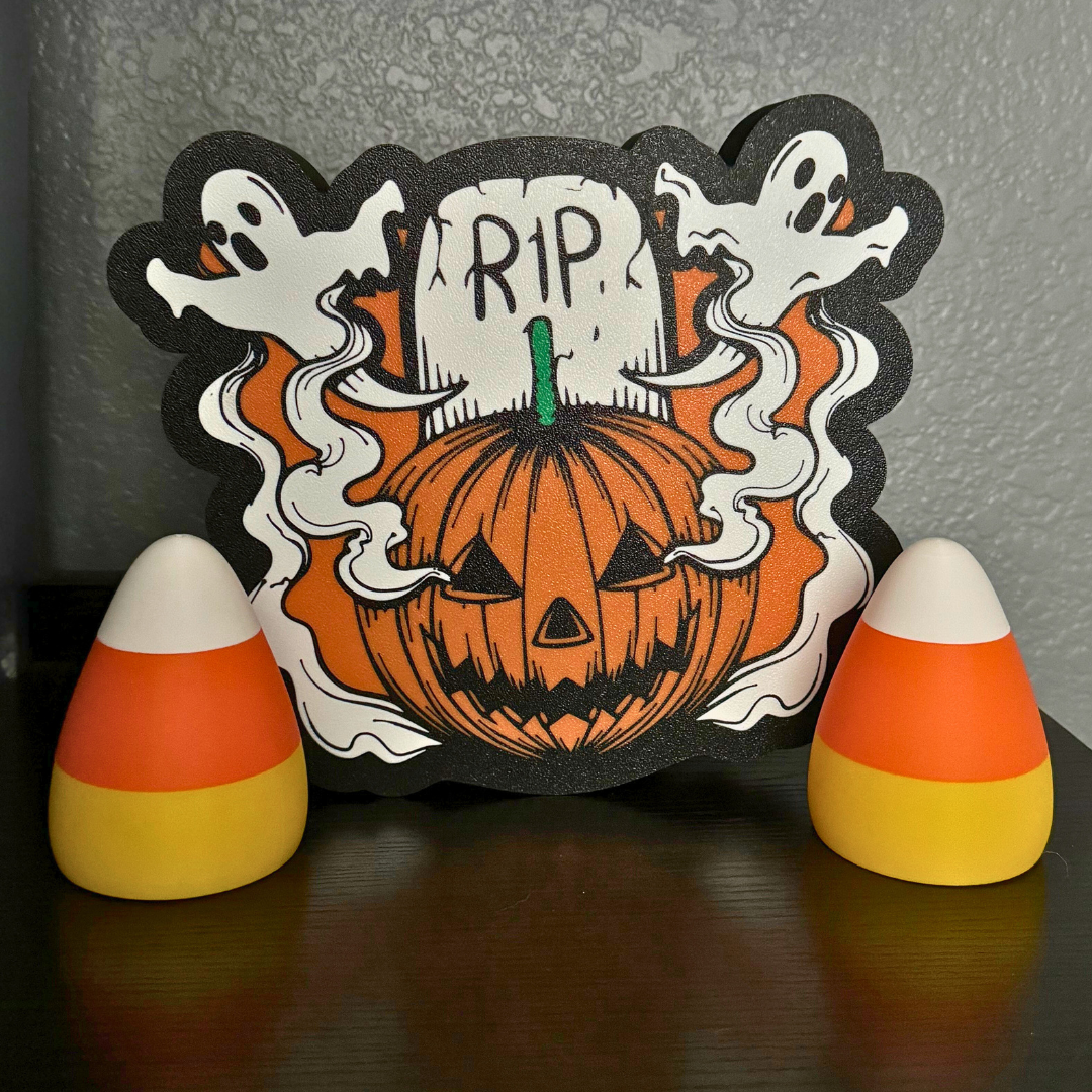 Two candy corn lights with their lights turned off sitting with a Halloween sign as fall decor on a bookshelf.