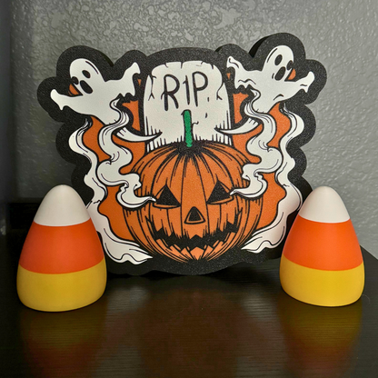 Two candy corn lights with their lights turned off sitting with a Halloween sign as fall decor on a bookshelf.