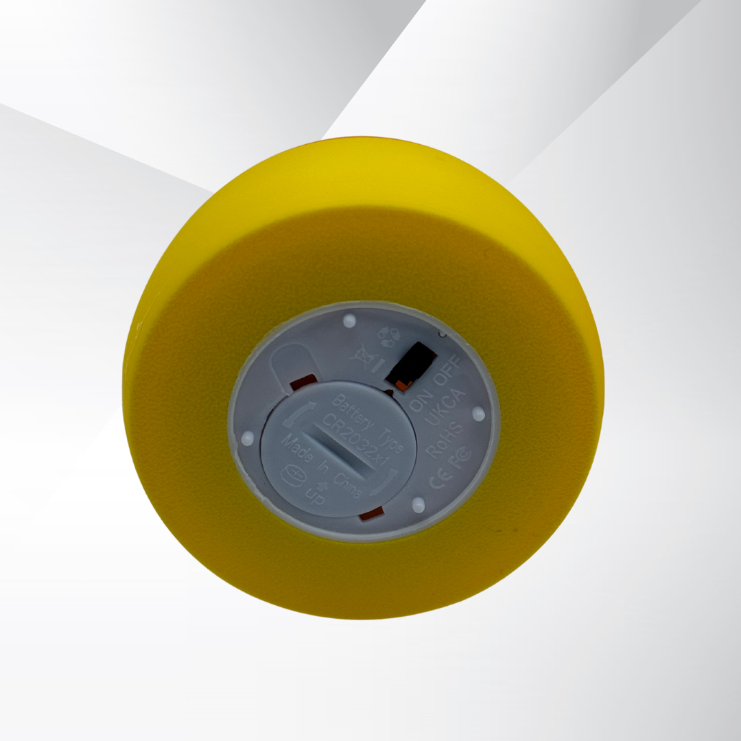 The view of the light switch at the bottom of the candy corn light with a silver and white background.