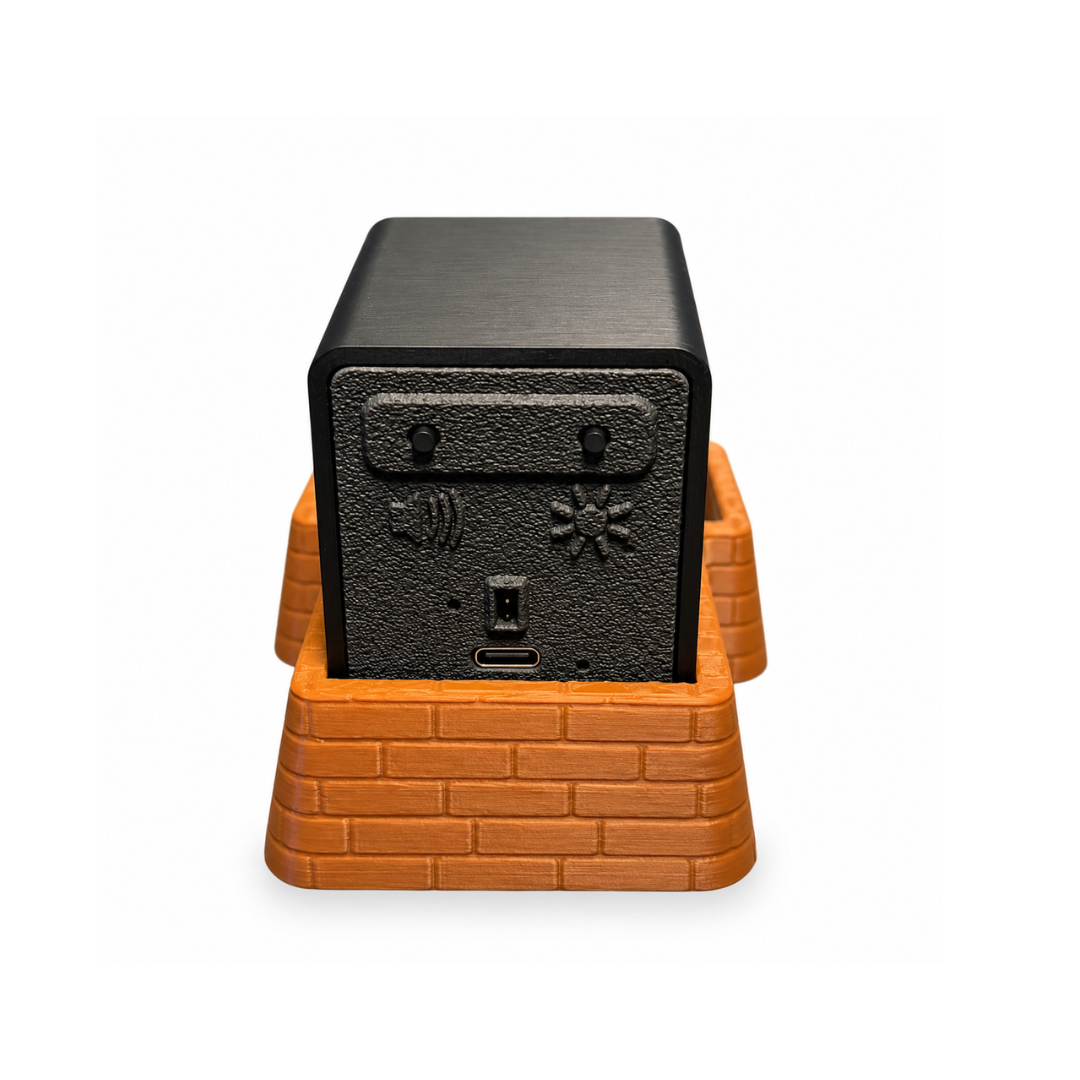 Back of the brown brick coin tray with a black Insert Coin Cube inside.