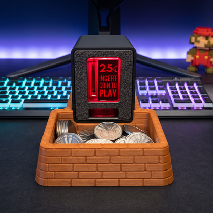 A brown brick coin tray with an Insert Coin Cube sitting on top filled with arcade tokens with a gaming keyboard and Mario figure in the background.