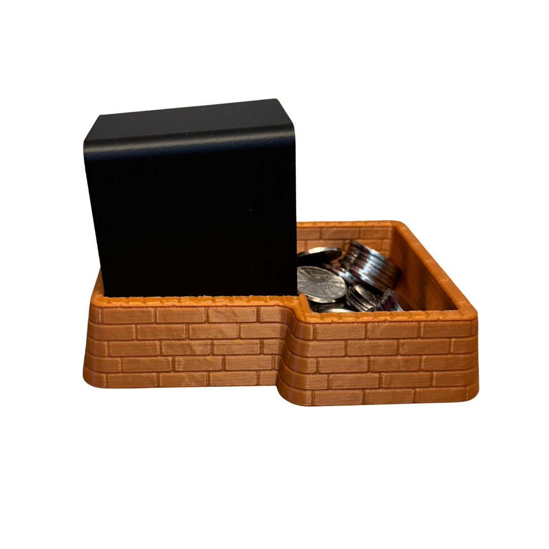 Right side of the brown brick coin tray with a black Insert Coin Cube inside.