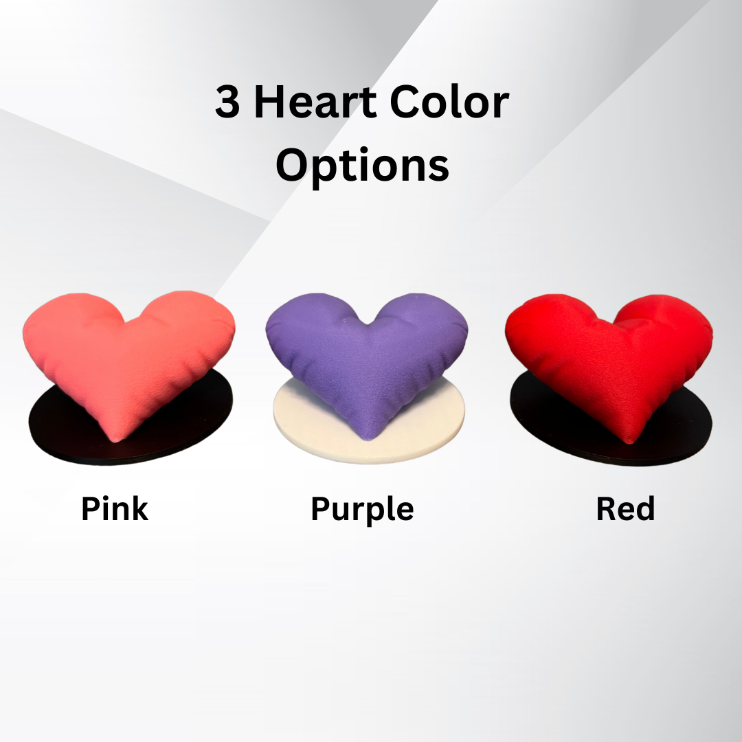 Three 3d printed heart sculptures showing the color variation options: pink, purple, or red heart with a black or white base.