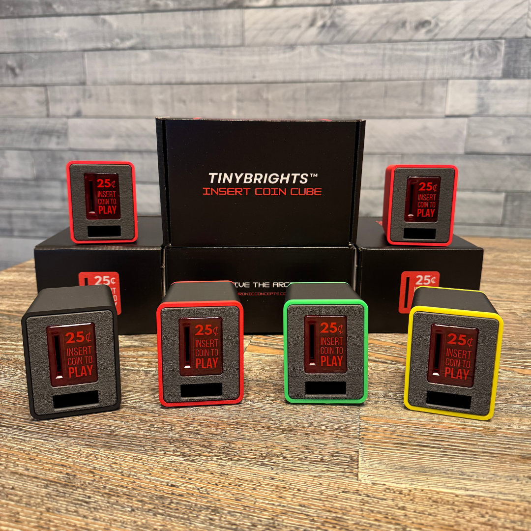 Five TinyBrights™ Insert Coin Cubes displayed in front of branded Chronic Concepts packaging, showcasing multiple color variations including red, yellow, green, and black.