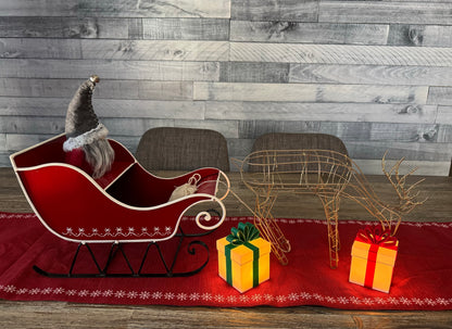 Christmas gift lights with Santa, Santa's sleigh, and a reindeer on a table runner on a dining room table.