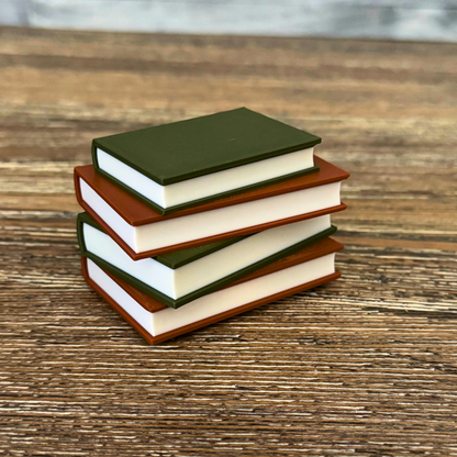 Cozy brown and green light up book stack sitting on a wooden shelf.