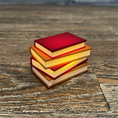 Cozy maroon and brown light up book stack lit up sitting on a wooden shelf.