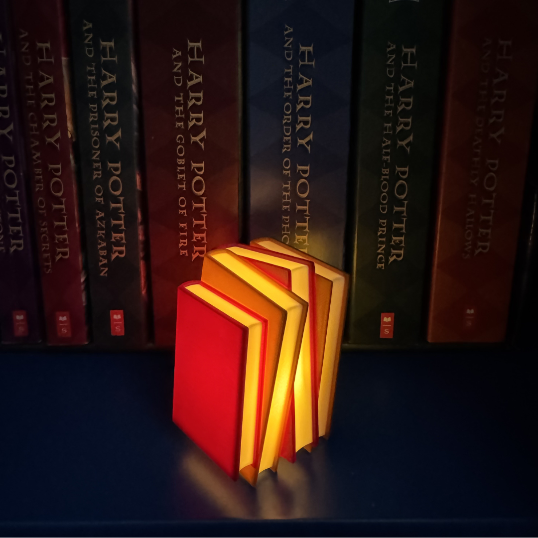 Maroon and brown book light standing up next to Harry Potter books showing off book pages.