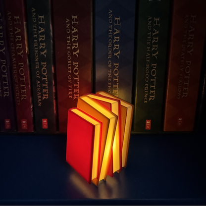 Maroon and brown book light standing up next to Harry Potter books showing off book pages.