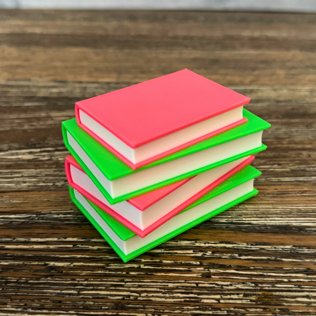 Neon pink and green light up stack of books sitting on a wooden bookshelf.