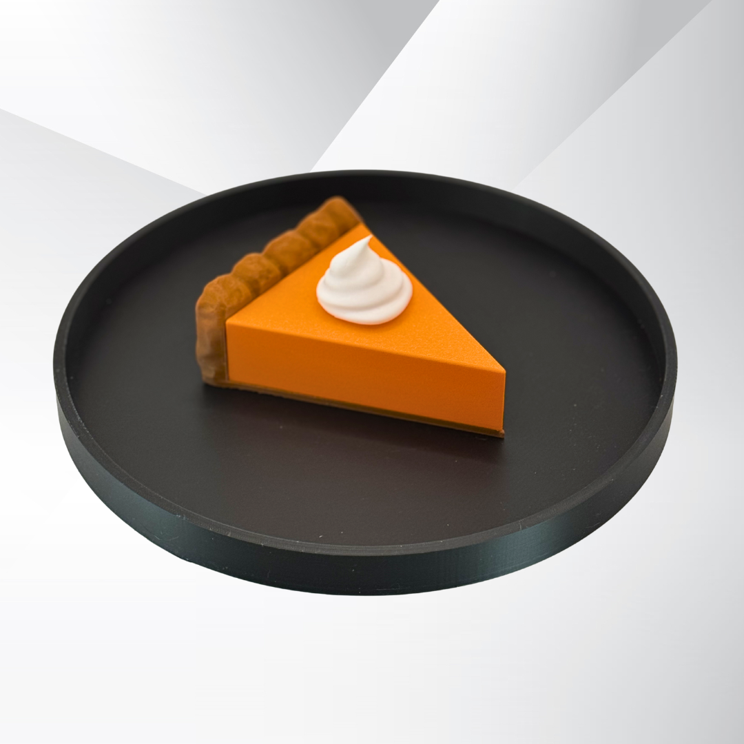 A pumpkin pie light with the light turned off sitting on a black tray with a white and silver background.