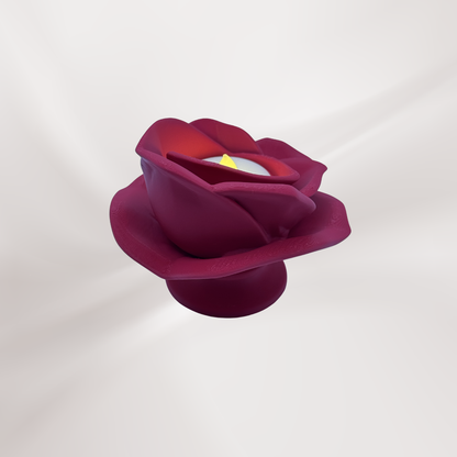 A back view of a 3d printed magenta rose tea light holder with a tea light turned on, on an off white background.