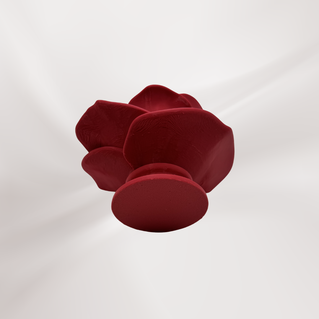 The bottom view of a 3d printed red rose tea light holder on an off white background.