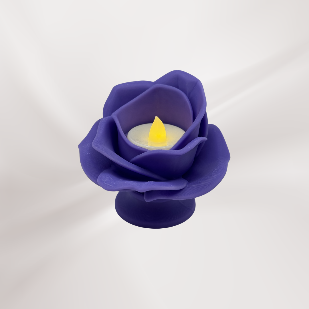 A lilac 3d printed rose tea light holder with a tea light turned on, on an off white background.