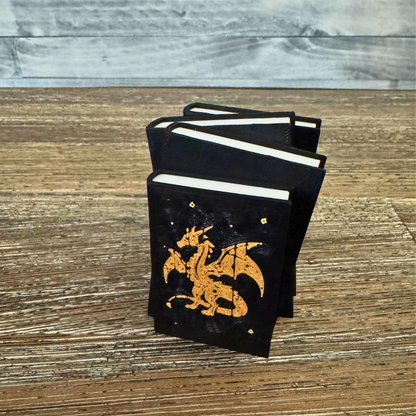 Dragon book stack standing upright on a wooden table.