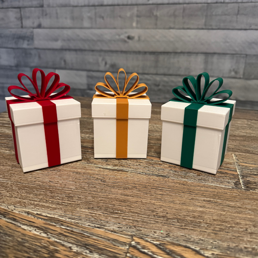 Three Christmas packages with their lights turned off sitting on a wooden table.
