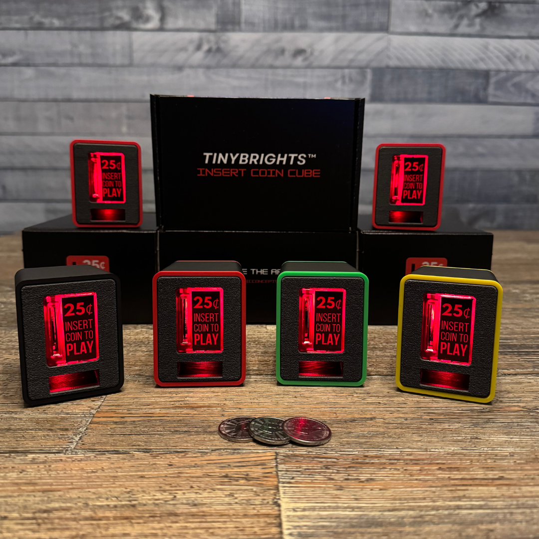 TinyBrights™ Insert Coin Cubes illuminated with bright red LED glow, arranged in front of Chronic Concepts display boxes to highlight the product’s light-up feature.