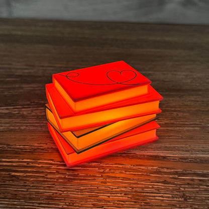 Romance novel light up stack of books lit up sitting on a wooden shelf.