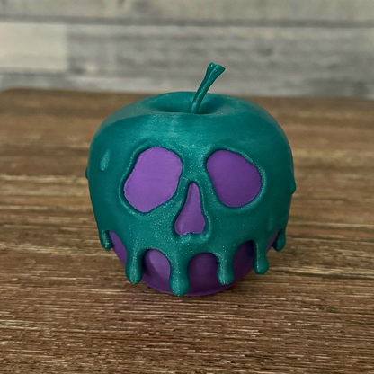 A purple and teal poison candy apple on a wooden table, ideal for Halloween decor.