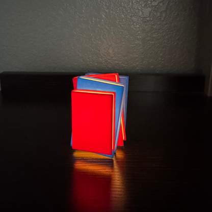 Vibrant red and blue light up stack of books standing up on a bookshelf.
